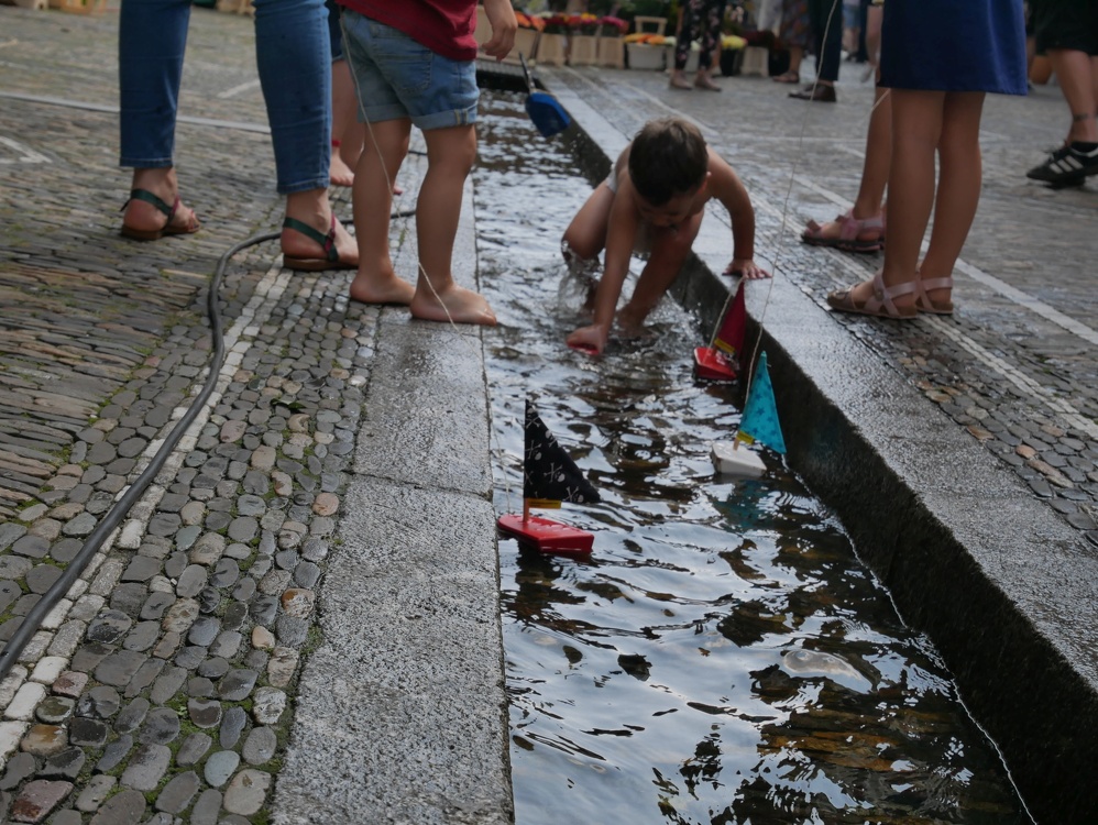 Freiburg im Breisgau Kind spielt Boot im Bächle