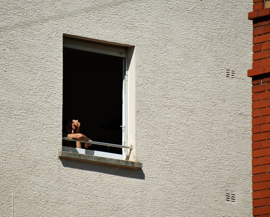 Mann im Schatten schaut aus dem Fenster
